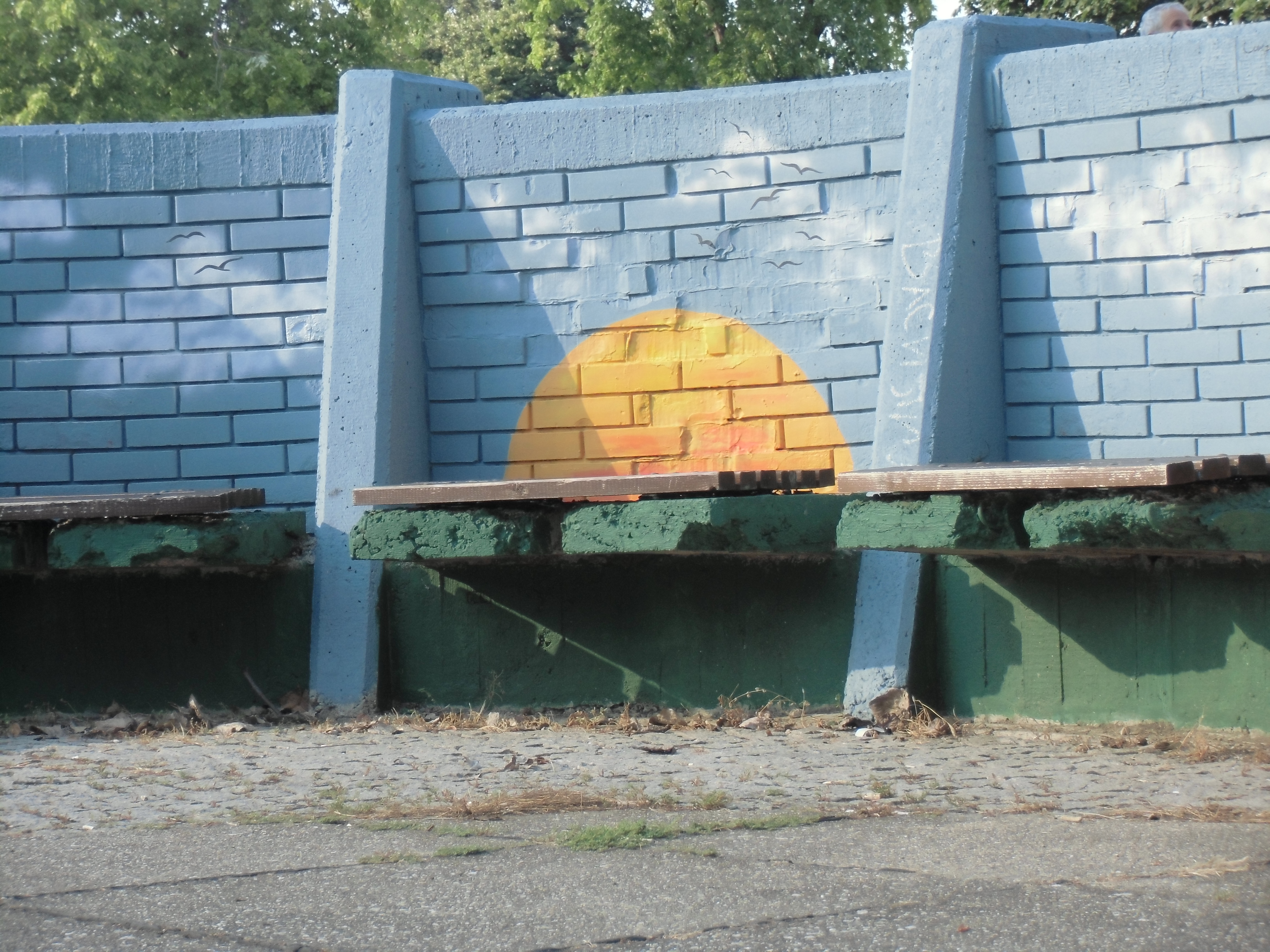 painted wall behind a bench, looks like a setting sun